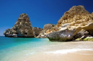 Vue panoramique des magnifiques plages de l'Algarve, mettant en valeur ses eaux cristallines, ses étendues de sable doré et les formations rocheuses qui ajoutent du caractère au paysage côtier, offrant ainsi un cadre idyllique pour les vacanciers amoureux de la nature et de la mer.