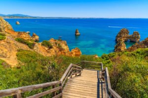 Vue panoramique des magnifiques plages de l'Algarve, avec ses eaux cristallines, ses étendues de sable doré, les roches orangées et la passerelle (passadiço) qui offre une vue pittoresque sur la côte, créant un cadre paradisiaque pour les vacanciers et les amoureux de la mer.