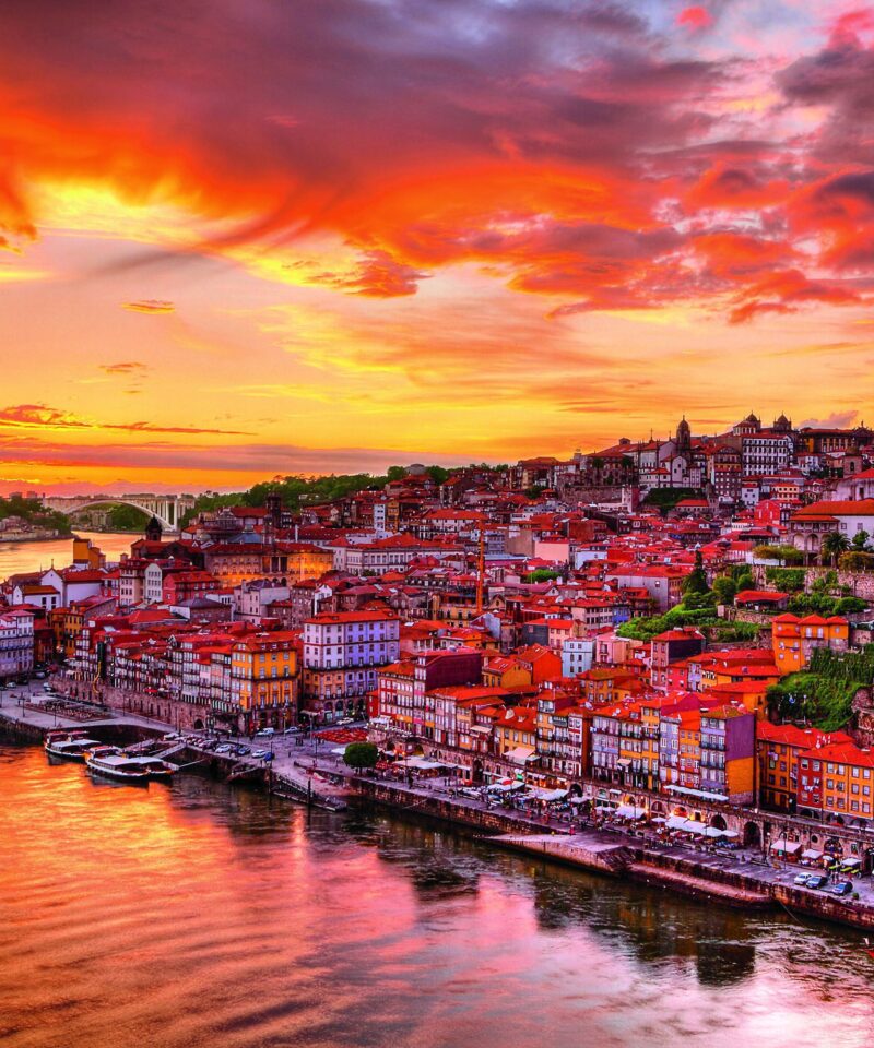 Vue depuis le Pont Dom Luís I et du Jardim do Morro à Vila Nova de Gaia, offrant une perspective panoramique sur Porto et le Douro, capturée en fin de journée avec les belles teintes du soleil couchant.