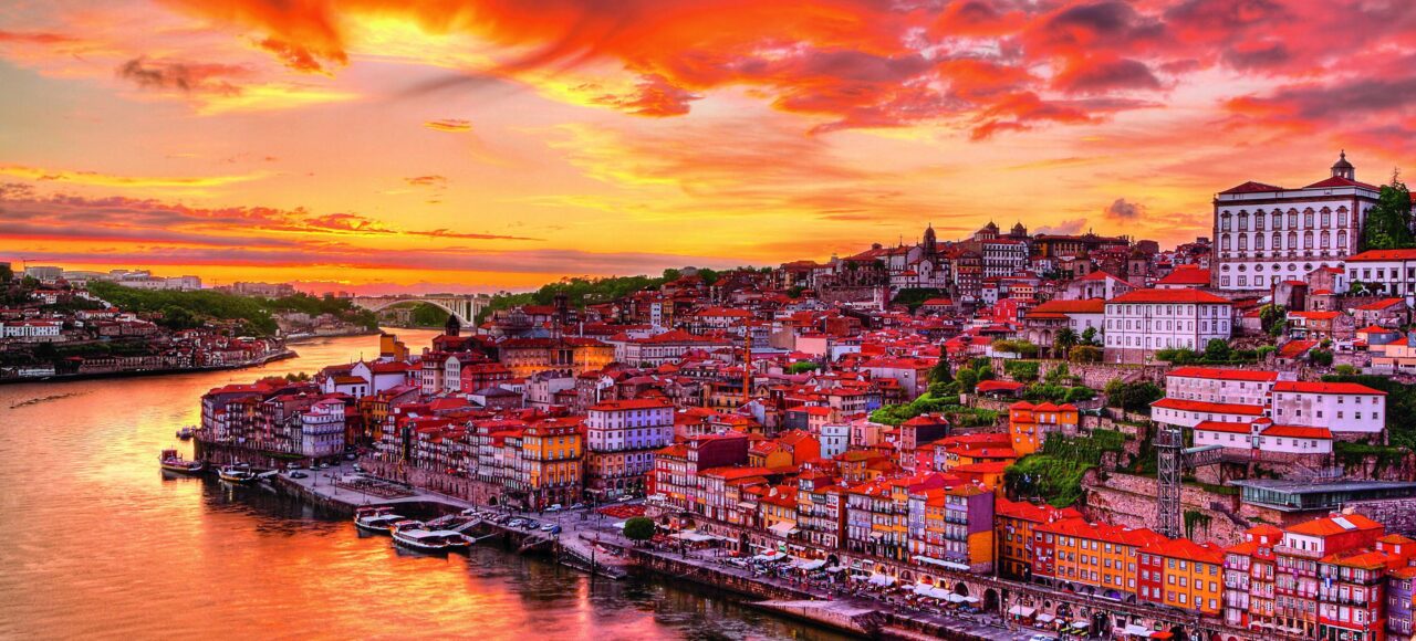 Vue depuis le Pont Dom Luís I et du Jardim do Morro à Vila Nova de Gaia, offrant une perspective panoramique sur Porto et le Douro, capturée en fin de journée avec les belles teintes du soleil couchant.