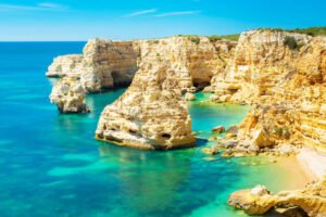 Vue panoramique des magnifiques plages de l'Algarve, avec ses eaux cristallines, ses étendues de sable doré, les roches orangées et la passerelle (passadiço) qui offre une vue pittoresque sur la côte, créant un cadre paradisiaque pour les vacanciers et les amoureux de la nature.